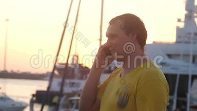 年轻微笑的胖子在夕阳下的海船上用手机说话，镜头耀斑效果。 3840x2160
